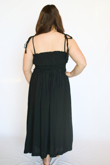 Woman wearing a black dress with thin straps 