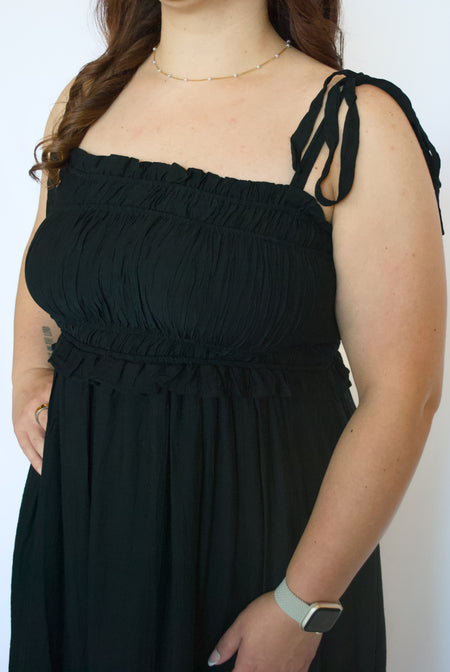 Person wearing a black dress with thin straps 