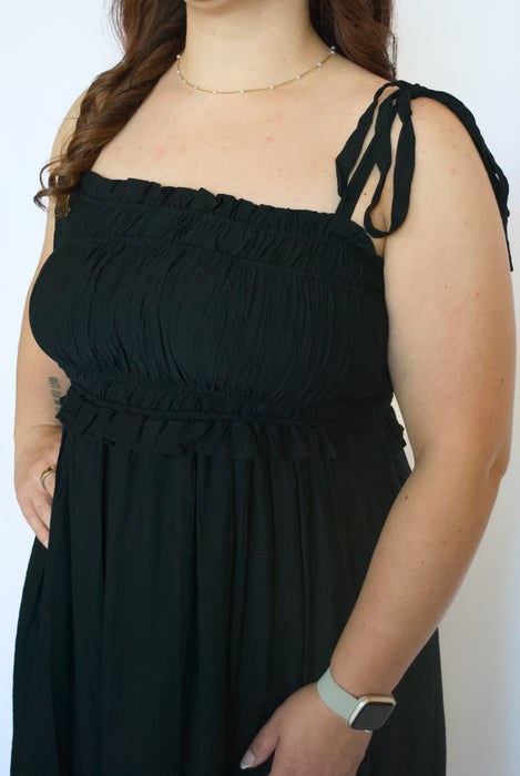 Person wearing a black dress with thin straps 