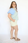 Woman wearing a colorful top and light shorts 