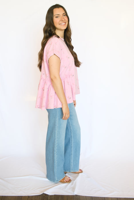Woman wearing a pink top and blue jeans 