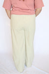 Person wearing a pink top and white striped pants 