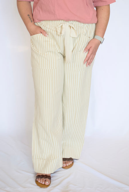 Person wearing light-colored striped pants and a pink top 