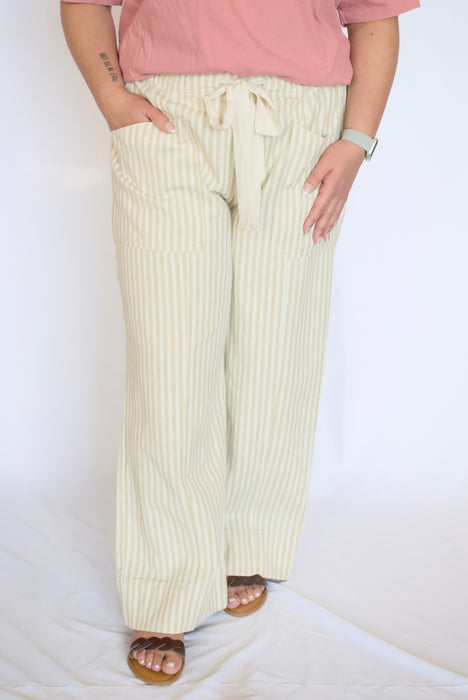 Person wearing light-colored striped pants and a pink top 