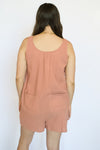 Person wearing a pink sleeveless romper 