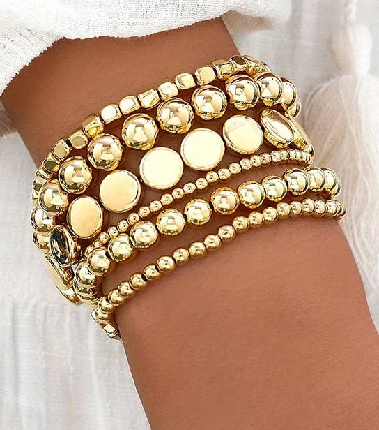 Gold beaded bracelet on a wrist 
