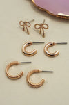 Set of gold earrings including bow-shaped and hoop designs 