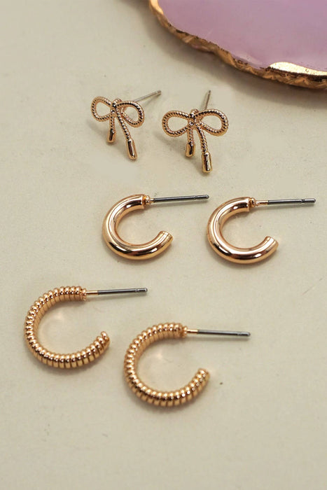 Set of gold earrings including bow-shaped and hoop designs 
